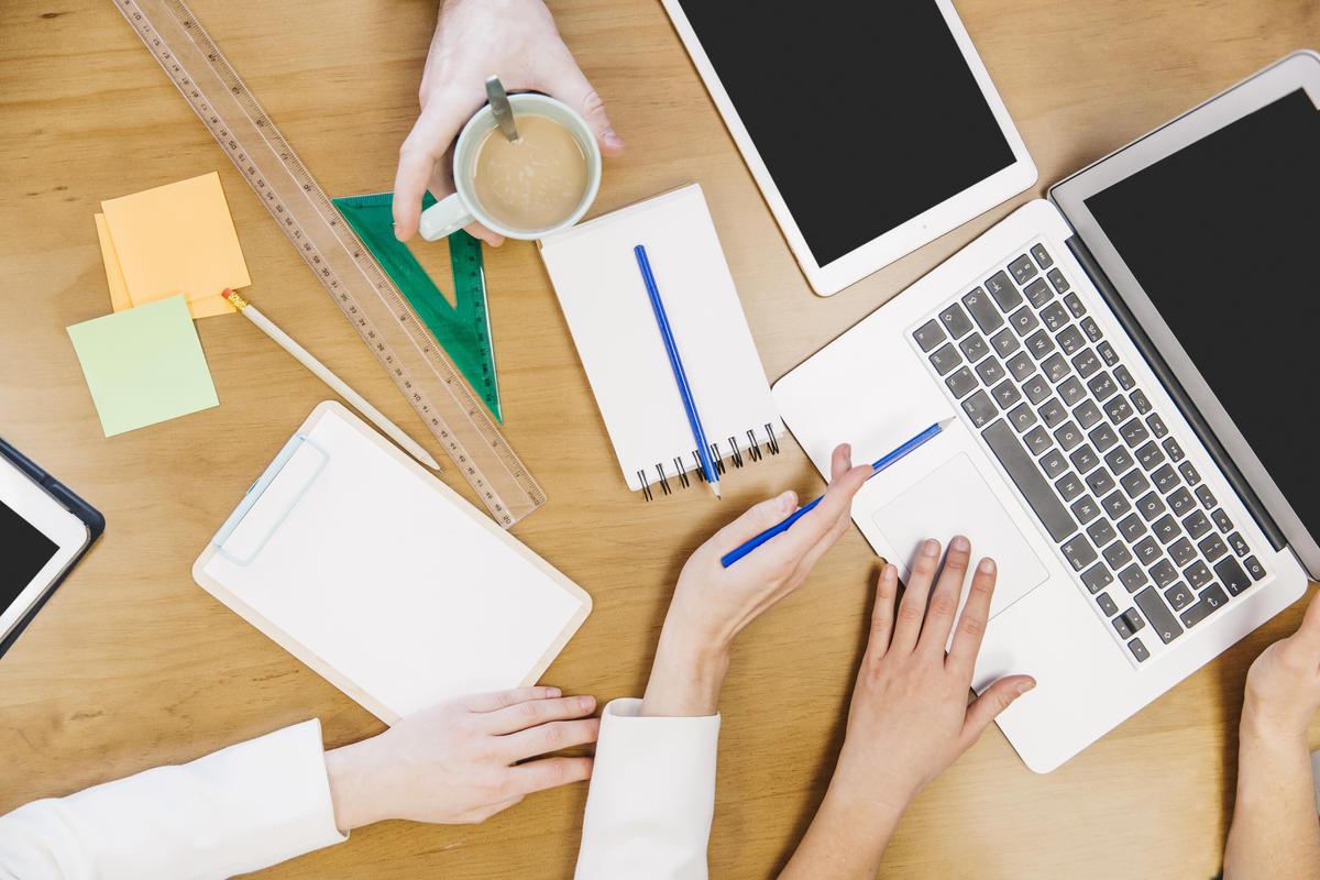 crop-colleagues-browsing-laptop-together