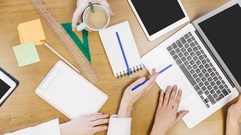 crop-colleagues-browsing-laptop-together